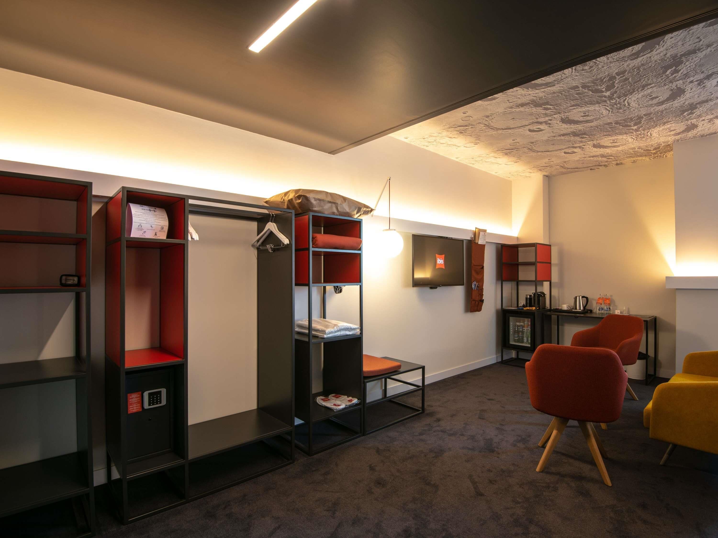 Een kamer met stapelbedden, een televisie, een bureau en een stoel.