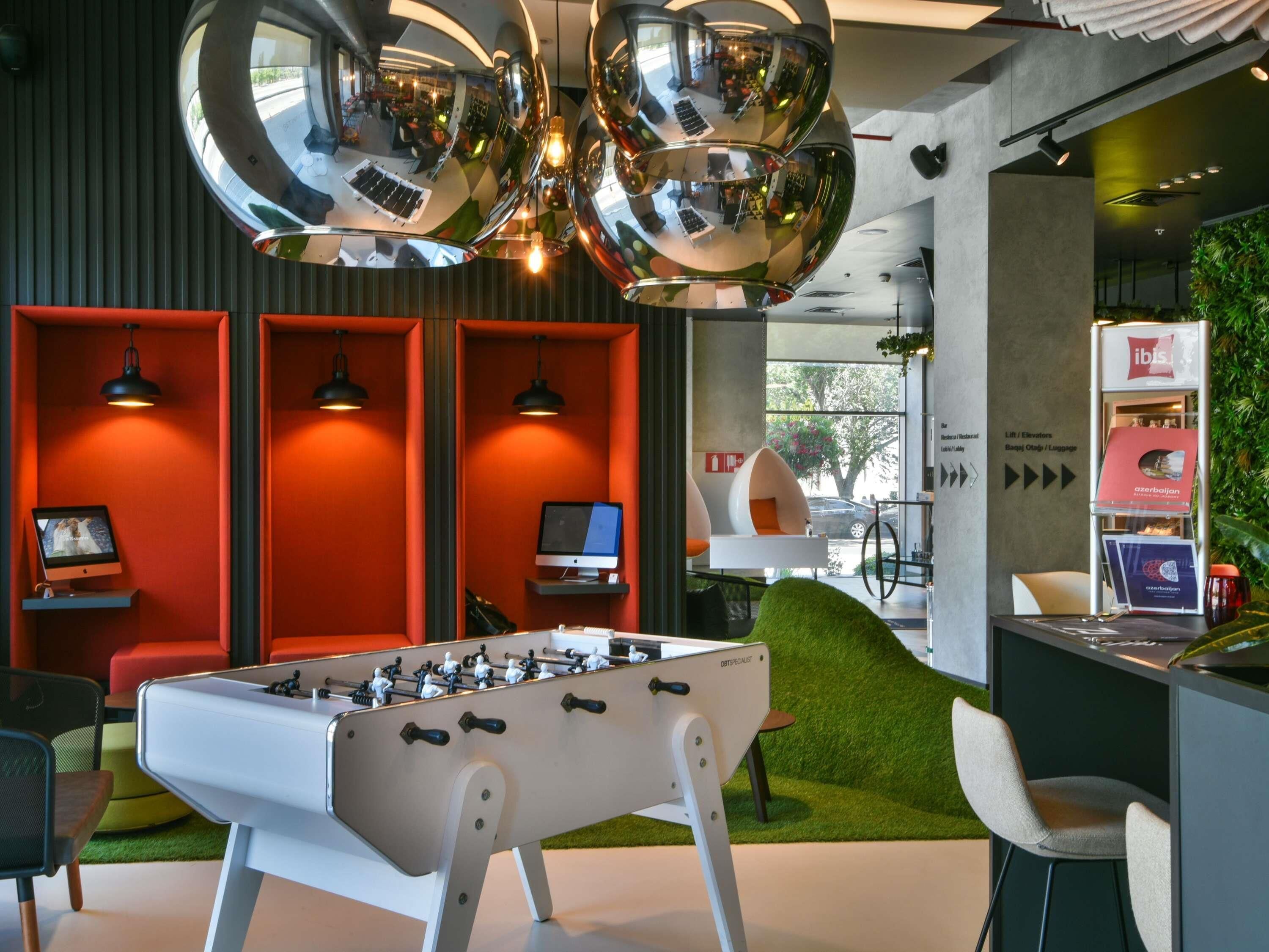 A modern interior with a foosball table, red seating, and a foosball table in the center.