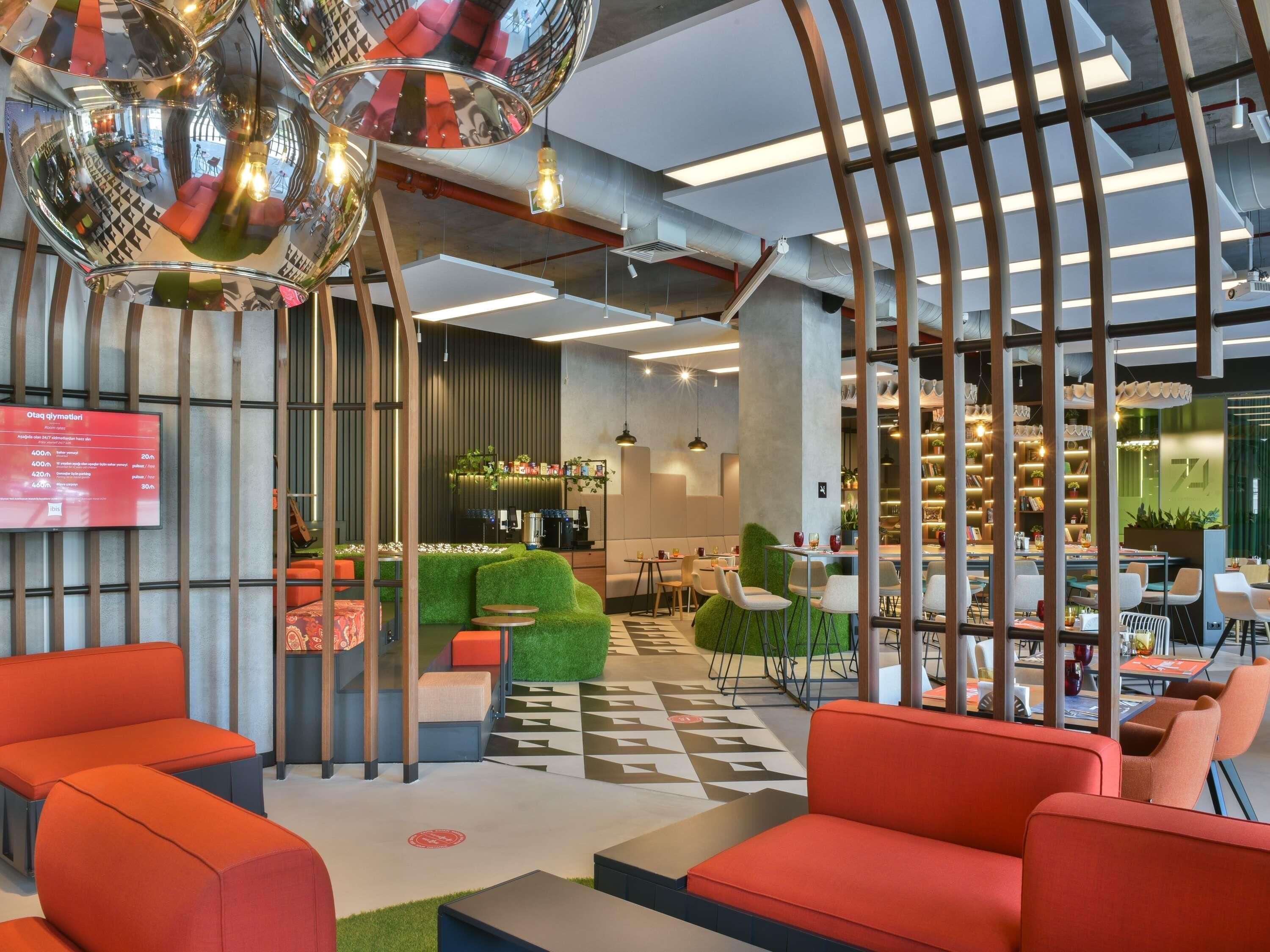 A modern interior with seating areas, a bar, and a visible menu board.