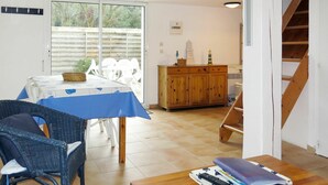 Un coin repas avec une table et des chaises, un meuble en bois et un escalier.