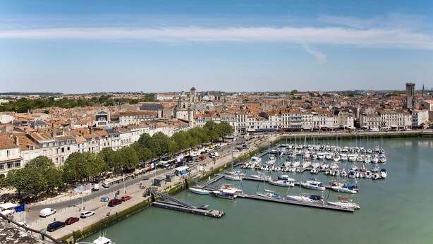 A marina with numerous boats docked, surrounded by a cityscape with historic buildings and a clear sky. - Cosy apartment for 4 people with WIFI, TV and terrace (La Grainetière)