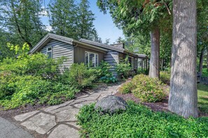A house with a stone pathway leading to the entrance, surrounded by lush greenery and trees. - Cabin in Downtown Ephraim-Perfect for couples! (Ephraim)
