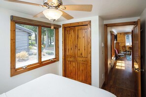 A bedroom with a bed, a ceiling fan, a wooden wardrobe, and a window with a view of the outdoors. - Cabin in Downtown Ephraim-Perfect for couples! (Ephraim)