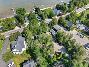 Luchtbeeld van een woonwijk met huizen, wegen en een steiger aan het water.