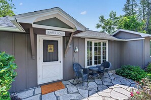 A house with a 'Welcome to the Summer House' sign, a front door, a window, and outdoor seating. - Cabin in Downtown Ephraim-Perfect for couples! (Ephraim)