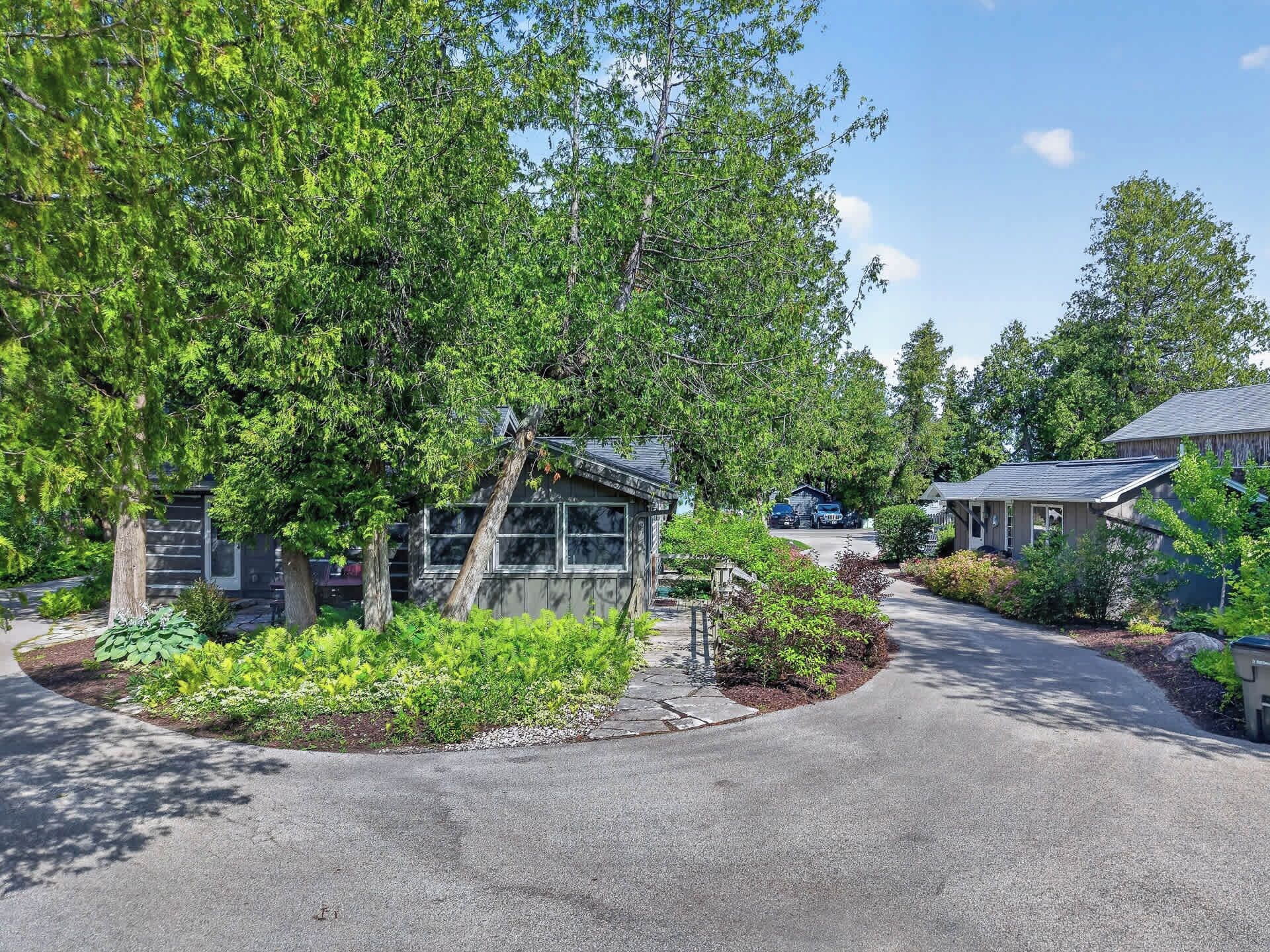 A residential area with houses, a driveway, and a well-maintained garden.