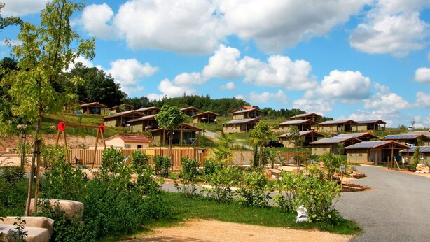 A series of wooden cabins with sloped roofs, arranged in a hillside layout. - Cosy apartment in villa for 6 guests with WIFI, pool, TV, terrace and pets allowed (Cazals)