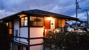 A traditional Japanese house with a tiled roof, wooden walls, and a small porch. - IzuRicca (Izunokuni)
