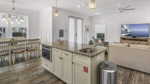 A modern kitchen with granite countertops, a built-in oven, and a stainless steel sink.