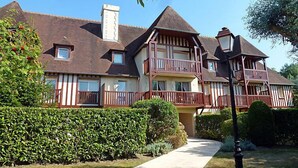A large, multi-story house with a prominent balcony, a chimney, and a well-maintained garden. - Domaine de Clairefontaine by Interhome (Deauville-Trouville)