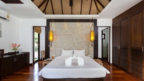 Un dormitorio amplio con una cama grande, techo de madera y pared de piedra.