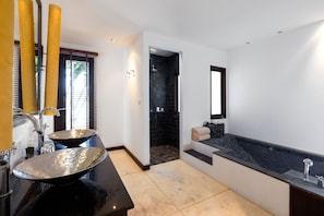 A modern bathroom with a large black bathtub, a round sink, and a shower area. - Sensive Hill Villas (Kathu)