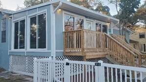 Un petit bâtiment d’un seul étage, doté d’une terrasse en bois et d’une clôture blanche faite de piquets.