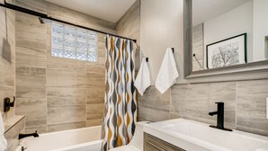 Une salle de bain moderne équipée d’une douche, de toilettes et d’un lavabo.