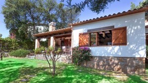 A house with a stone foundation, a wooden roof, and a covered porch. - La Plaza by Interhome (Calonge)