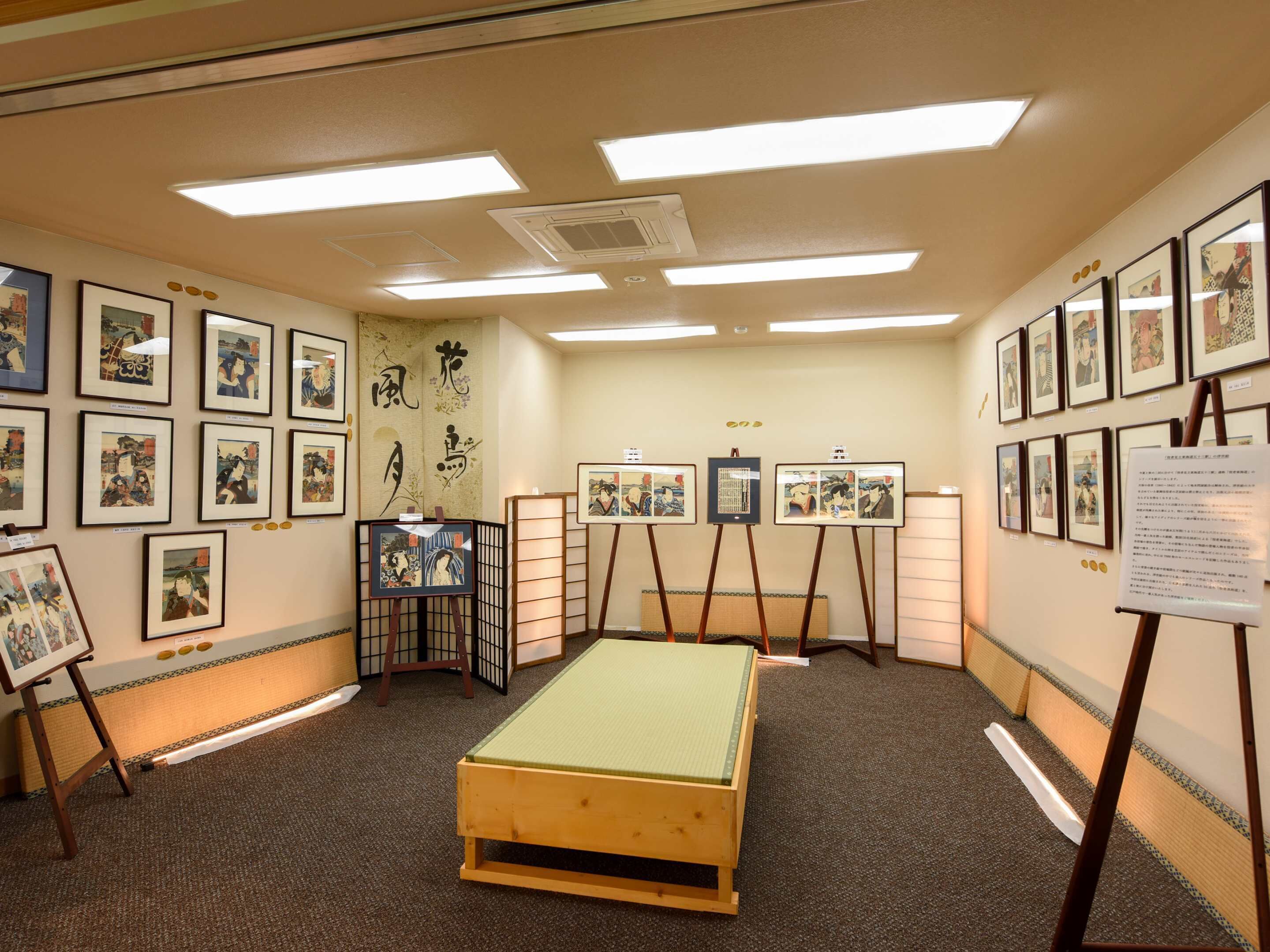 Et værelse med traditionel japansk stil, med tatami-gulv, shoji-skærme og kunst på væggene.