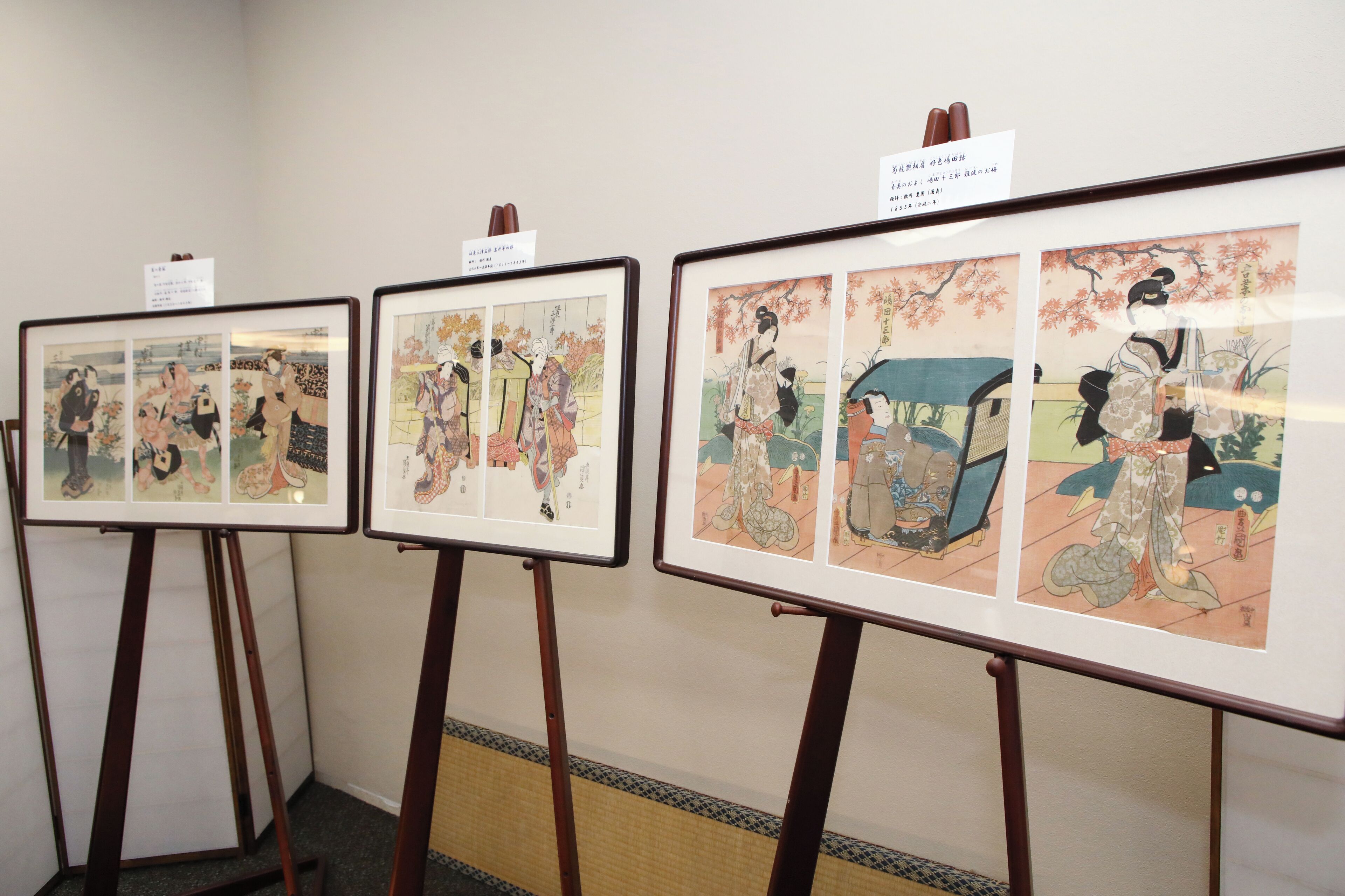 Framed artworks on easels in a gallery setting.