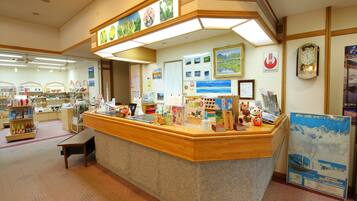 A well-lit reception area with a counter, informational posters, and a clock on the wall.