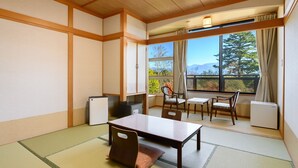 Una habitación al estilo japonés tradicional, con suelo de tatami, una mesa de madera y sillas.