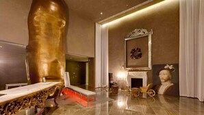 A luxurious room with a large golden sculpture, a fireplace, and a portrait on the wall. - Icon 2901 · ★ ICON BRICKELL-29th FLOOR OCEAN VIEWS-FREE SPA★ (Miami)