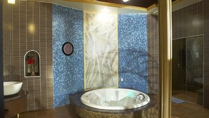 Ein Badezimmer mit einer großen Badewanne, einem Waschbecken und einem Spiegel.