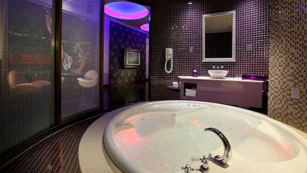 Ein modernes Badezimmer mit einer großen Badewanne, einem Waschtisch mit Spiegel und einer Duschkabine.