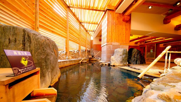 Un área de aguas termales con vigas de madera y paredes de piedra.