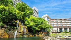 Un hotel con una cascada y abundante vegetación.