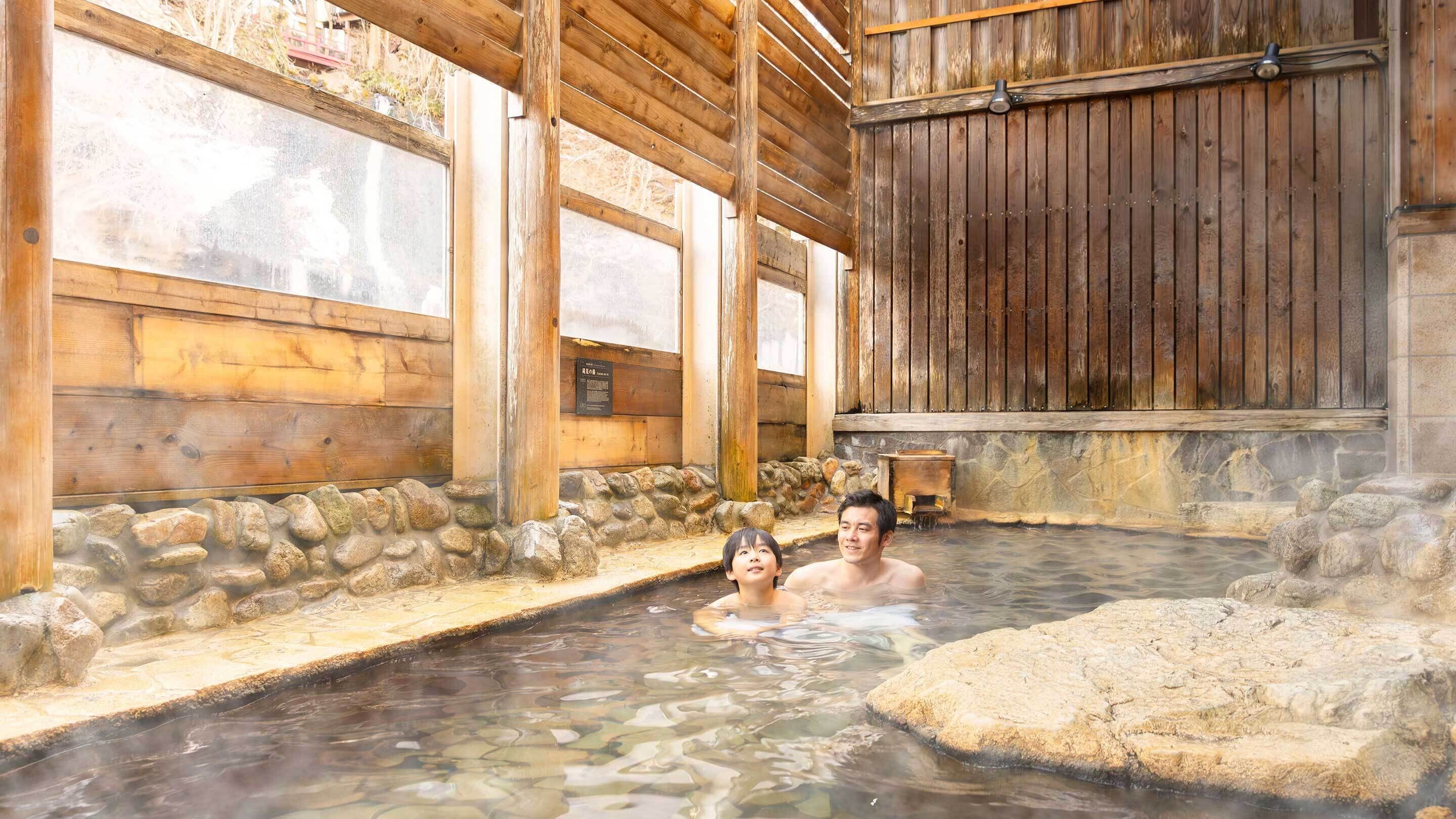 A traditional wooden bathhouse with stone walls and a wooden ceiling.