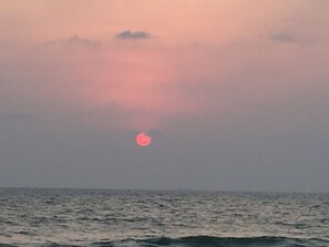 A sunset over the ocean with a clear sky.