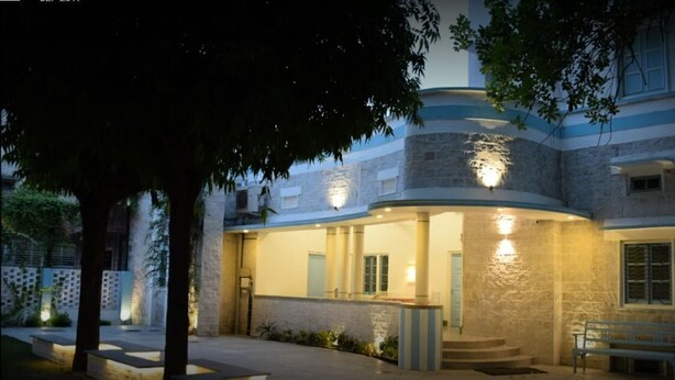 A building with a curved facade, stone exterior, and a well-lit entrance. - Jaipur Jantar Hostel (Jaipur)
