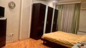 Une chambre à coucher avec un lit, une armoire et un téléviseur.