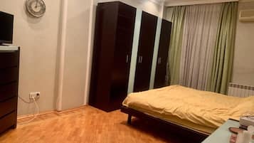 A bedroom with a bed, wardrobe, and a TV.