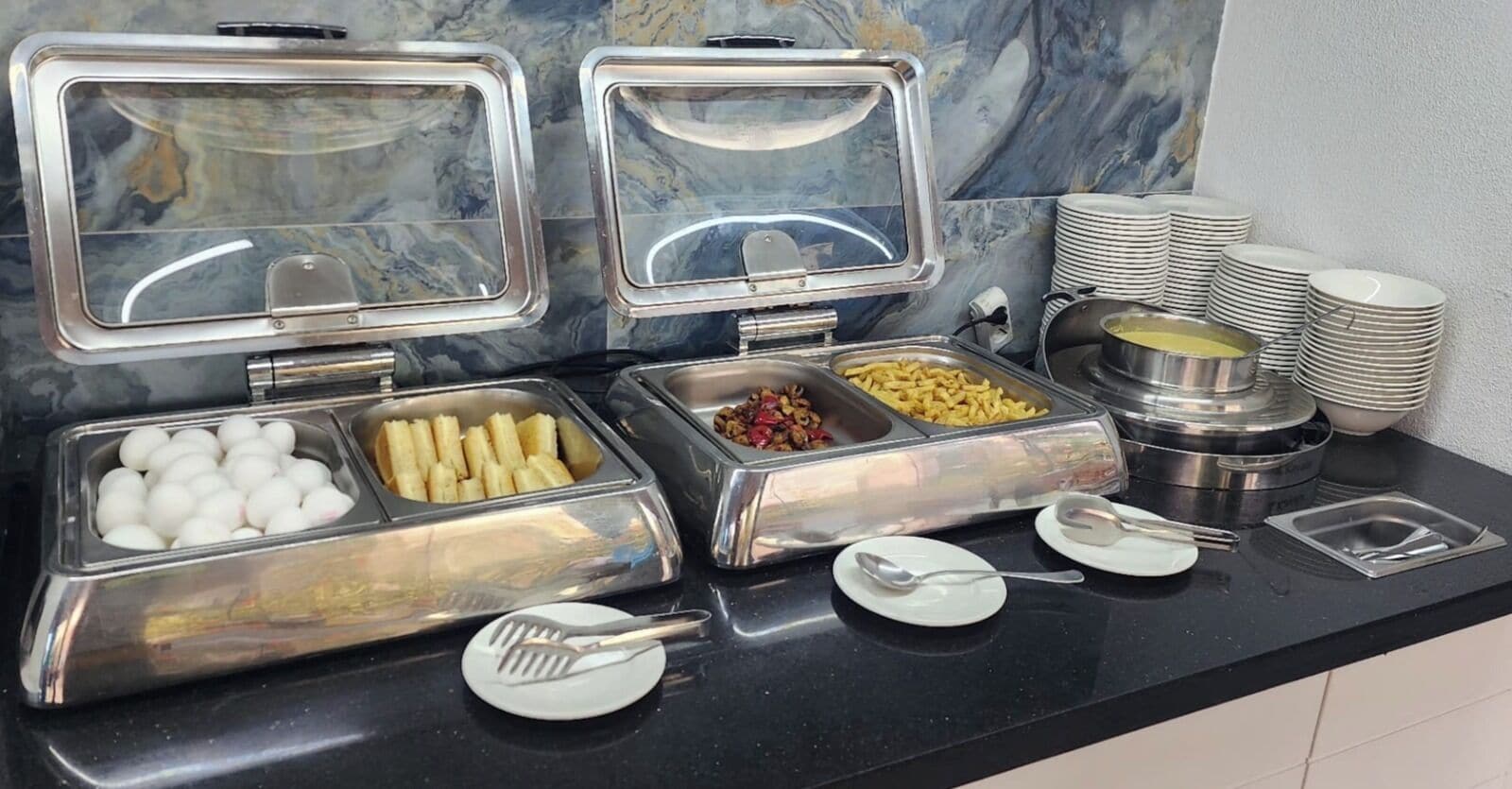 Een buffetopstelling met diverse gerechten en bestek.