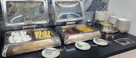 A buffet setup with various food items and utensils.