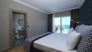 A hotel room with a bed, a bathroom with a mirror, and a balcony with a view of the sea. - Sea City Devran Hotel & Spa (Konyaalti)