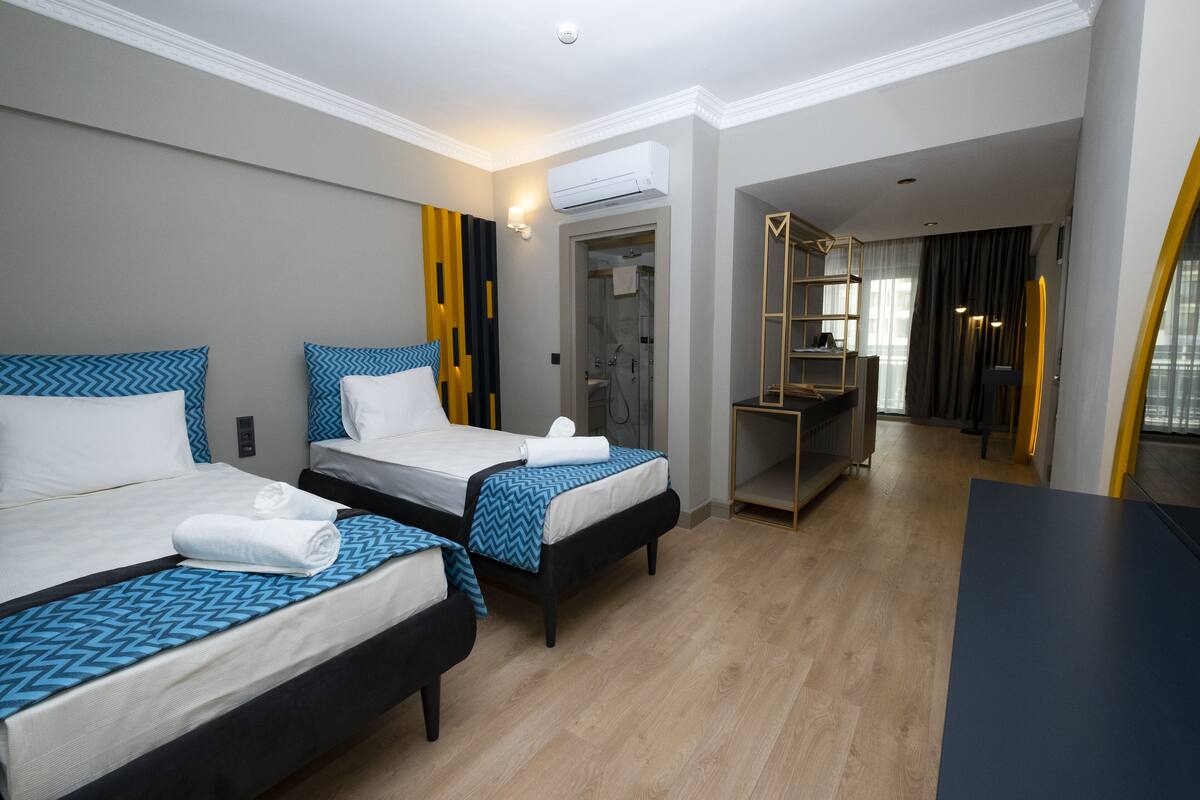 A hotel room with two beds, a desk, and a walk-in closet.