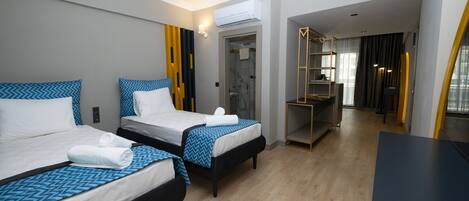 A hotel room with two beds, a desk, and a walk-in closet.