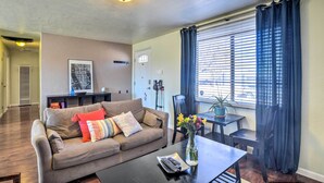 Ein Wohnzimmer mit Sofa, Couchtisch und Essbereich mit Tisch und Stühlen.