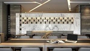 A modern conference room with marble walls, a central display of framed items, and a laptop on a table.