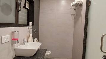 Ein kleines Badezimmer mit einem weißen Waschbecken, einem Spiegel, einem Handtuchhalter und einer Toilette.