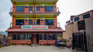 A multi-story building with balconies, a sign reading "HOTEL MARIGOLD NAGARKOT," and a reception desk. - Hotel Marigold (Mahamanjushree Nagarkot)