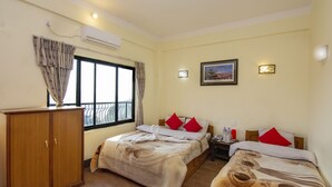 A hotel room with two beds, a wardrobe, a window with curtains, an air conditioner, a nightstand, and a wall-mounted picture. - Hotel Marigold (Mahamanjushree Nagarkot)