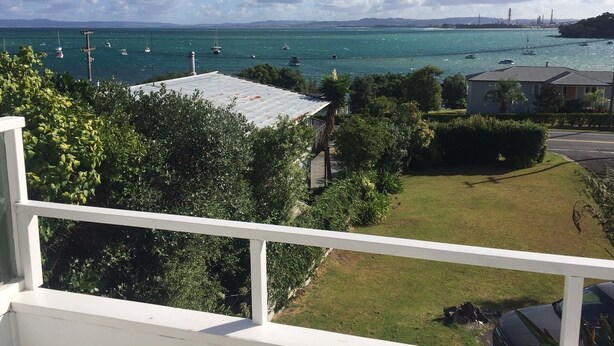 A coastal view with a clear sky, a grassy area, and a body of water with boats. - Come and Relax @ Rose's Retreat (with WIFI) (Whangarei Heads)