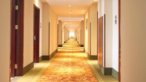A long, narrow hotel corridor with carpeted floors and doors on both sides. - Greentree Inn Beijing Daxing District Yufa Town Ne (Daxing)