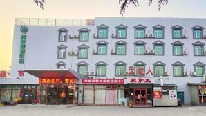 A hotel with multiple floors, large windows, and a variety of storefronts in front.
