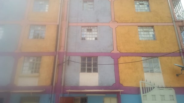 A multi-story building with a distinct architectural style, featuring a combination of yellow, purple, and blue colors. - Famouse Guest House (Nairobi)
