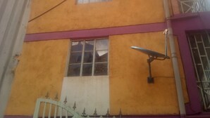 A multi-story building with a yellow facade, a purple lower section, and a white upper section. - Famouse Guest House (Nairobi)