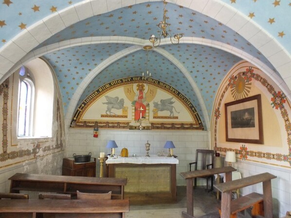 A church interior with pews, a central altar, and a ceiling with star patterns. - Chateau du Donjon (Drumettaz-Clarafond)