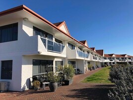 Un hotel moderno con fachada blanca, techo rojo y varios balcones.